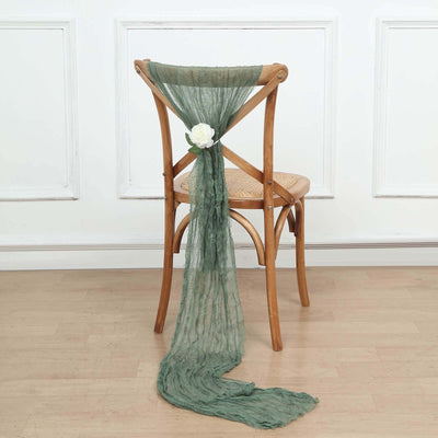Green chiffon chair scarf with white flower accent on wooden chair.