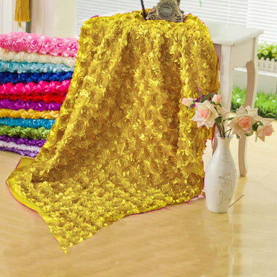 Yellow floral textured fabric draped elegantly with colorful roses in the background.