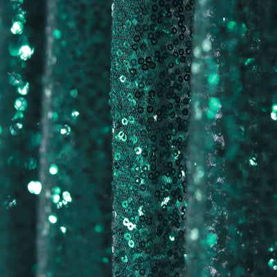 Shimmering teal sequin fabric with a sparkling texture.