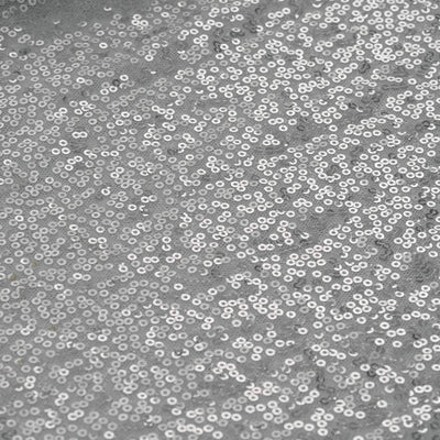 Silver sequin fabric texture with sparkling details.