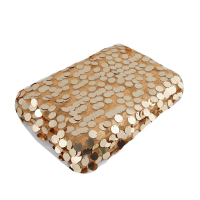 Gold sequin-covered clutch bag on plain backdrop