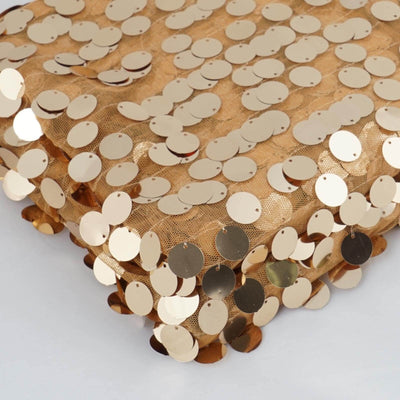 Gold sequin fabric with circular embellishments on a textured surface.