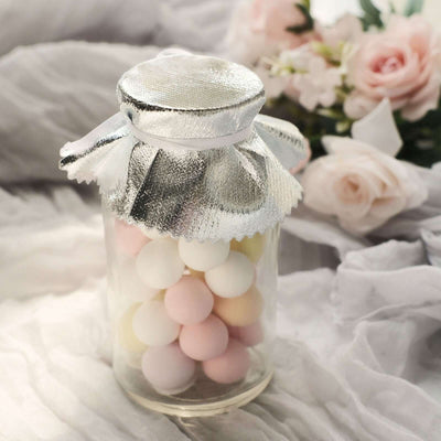 Glass jar filled with colorful candy balls, topped with a silver lid.