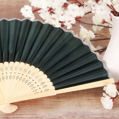 Elegant green folding fan displayed with floral accents.
