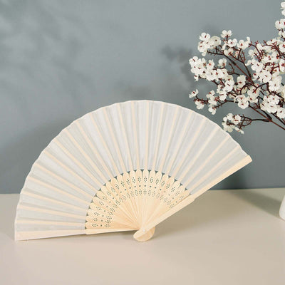 Elegant white folding fan displayed beside a decorative branch.