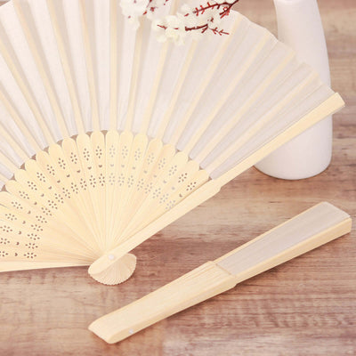 Elegant bamboo hand fan and comb set on a wooden surface.