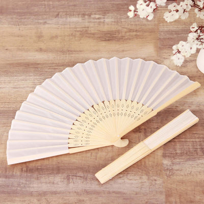Elegant white folding fan with intricate detailing and wooden handle.
