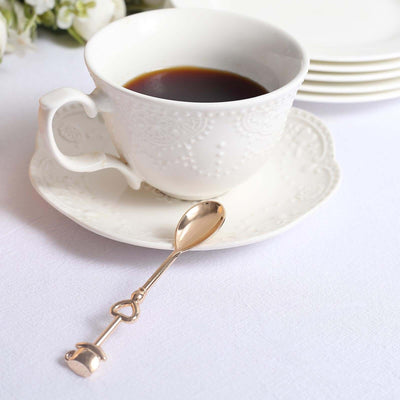 Elegant white teacup with coffee and a gold heart-shaped spoon