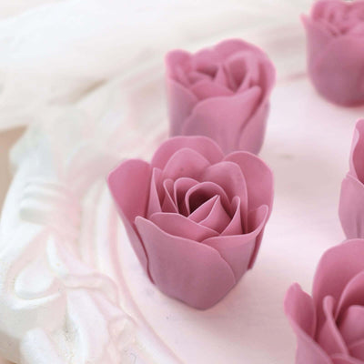 Pink rose-shaped candles arranged on a decorative tray.