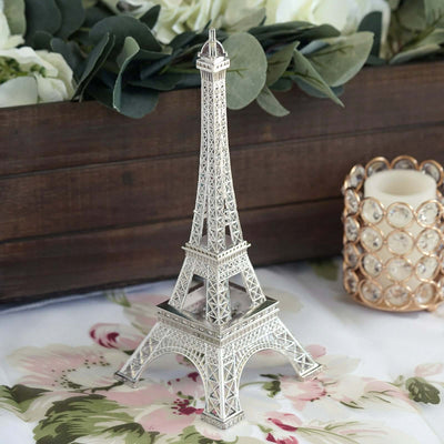 Silver Eiffel Tower figurine on floral table setting.