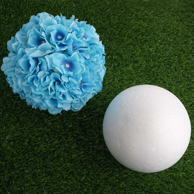 Blue floral ball and white foam sphere on green grass backdrop.