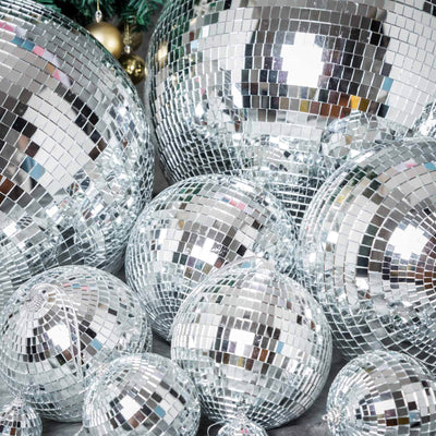 Silver disco balls of various sizes on a festive background.