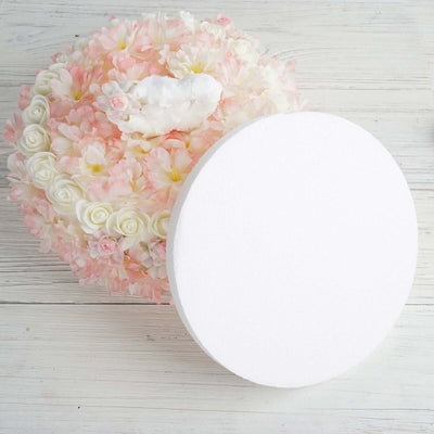 Floral arrangement with white and pink flowers and a decorative heart centerpiece.