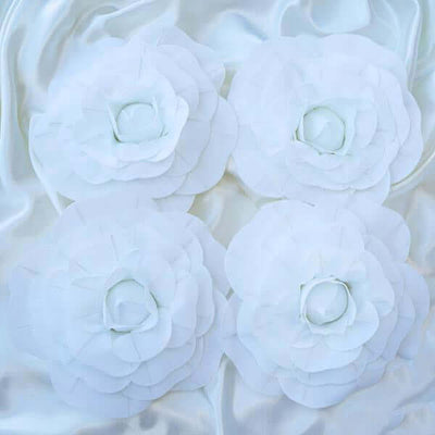 White fabric flowers arranged elegantly on a silky background.