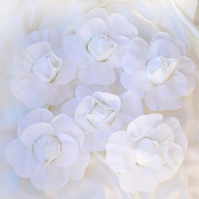 Six elegant white fabric flowers arranged on a soft white background.