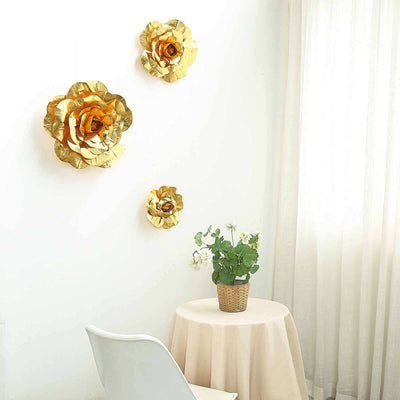 Gold paper flowers decor on a wall with a table and plant in a bright room.