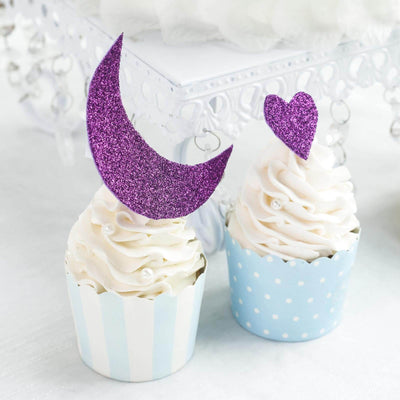 Cupcakes with glittery moon and heart toppers in blue and white liners.