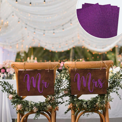Rustic wedding chairs with "Mr" and "Mrs" signs adorned with greenery and fairy lights.