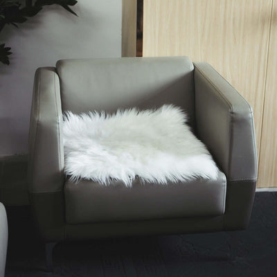 Modern gray armchair with a cozy white faux fur cushion.