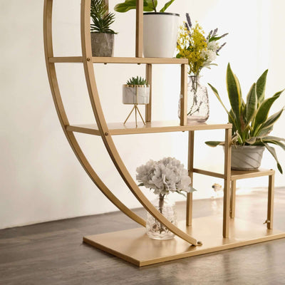 Gold open bookshelf with plants and decorative items.