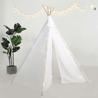 White play tent with fairy lights and decorative pom-poms.