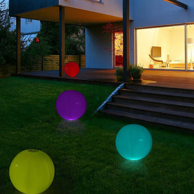 Colorful outdoor glowing balls in a garden at night.