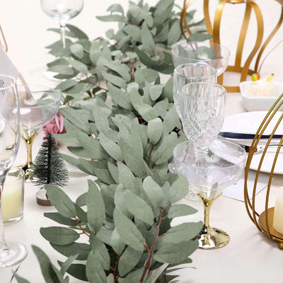Eucalyptus garland on a dining table with glassware and decorative elements.