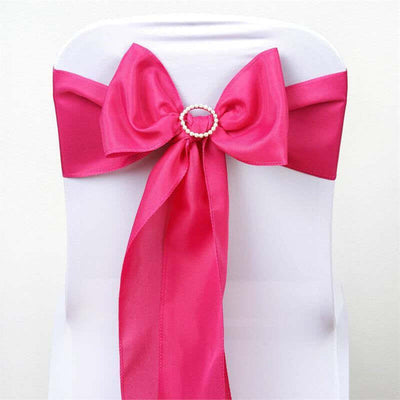 Pink satin chair sash with a decorative pearl buckle.