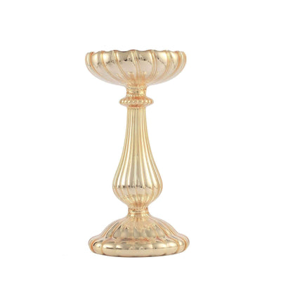 Gold candle holder with a fluted design and ornate base.