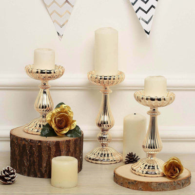 Elegant gold candle holders with decorative flowers on rustic wood bases.