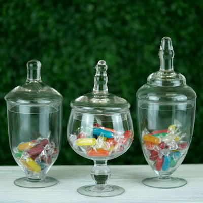 Glass candy jars filled with colorful sweets on a textured background.