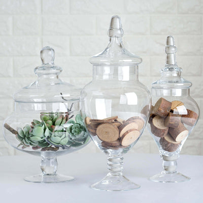 Three decorative glass jars filled with succulents and wooden pieces.