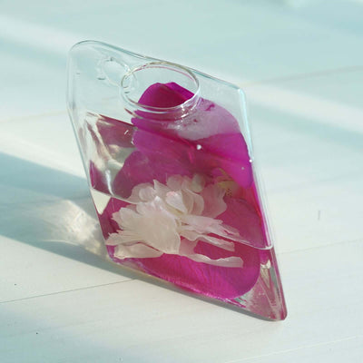 Clear bottle with pink and white flowers submerged in water.