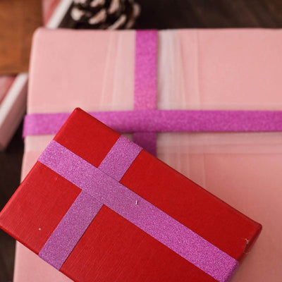 Colorful gift boxes with glittery ribbons on a wooden surface.