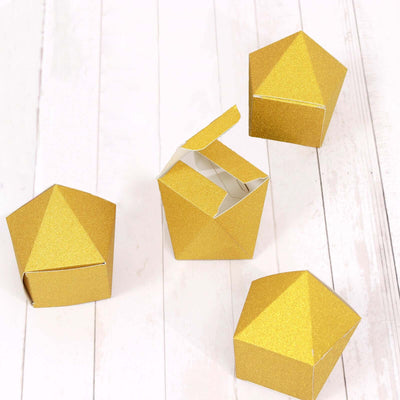 Gold geometric gift boxes arranged on a wooden surface.