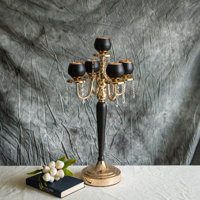 Elegant black and gold candelabra with crystal accents on textured backdrop.