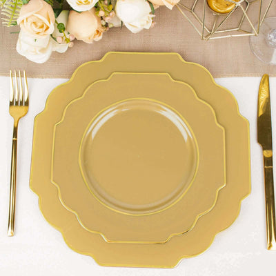 Gold scalloped dinnerware set on a table with elegant floral arrangement.