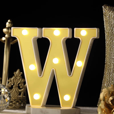 Yellow marquee letter "W" with lights, decorative home accent.