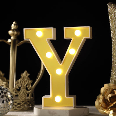 Yellow marquee letter "Y" with lights, surrounded by decorative elements.