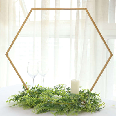 Hexagon frame with greenery, candles, and glasses in a bright setting.