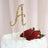 Gold glitter cake topper letter "A" on a decorated cake with strawberries.