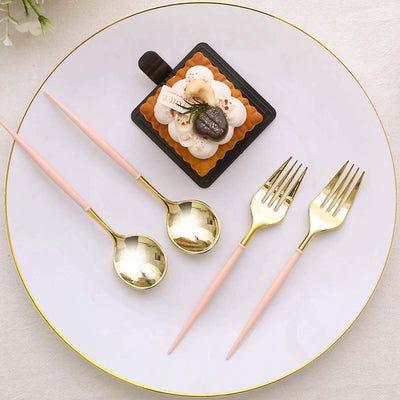Elegant gold and pink cutlery set with a dessert on a white plate.