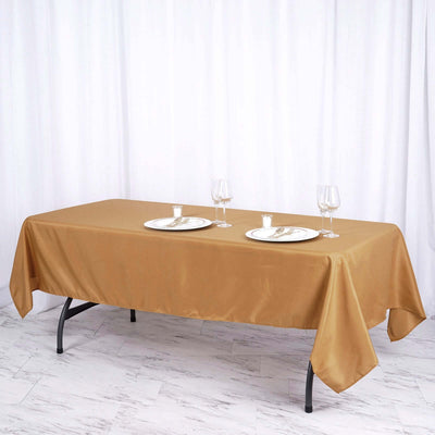 Elegant gold tablecloth on a dining table set for two.