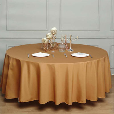 Round brown tablecloth draped over a table set for a meal.