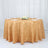Round gold tablecloth with geometric design on a dining table setting.