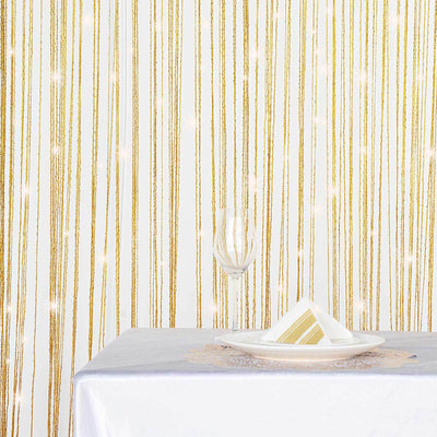 Elegant table setting with gold striped backdrop and glassware.