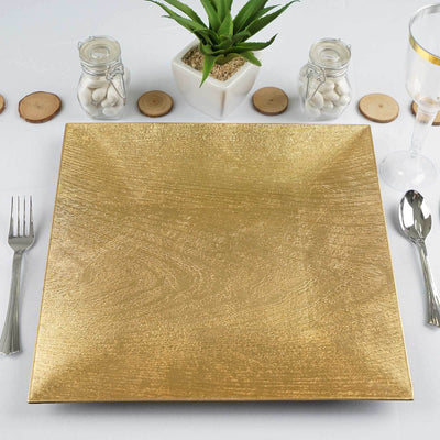 Gold decorative plate on a table setting with utensils and a plant.