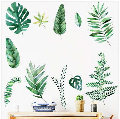 Assorted green leaf wall decals arranged around a desk with a typewriter.