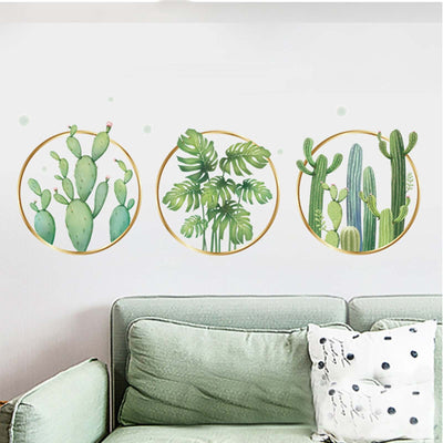 Cactus and plant wall art in circular frames above a green sofa.