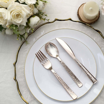Elegant silver cutlery set on a decorative plate with white roses.